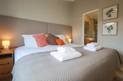 a bedroom with a large white bed with towels on it at 4 Meadow Retreat in Liskeard