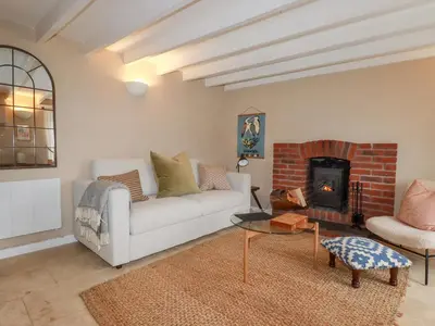 a living room with a couch and a fireplace at Waterside Cottage in Truro