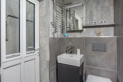 a bathroom with a sink and a toilet and a mirror at Loe Cottage in Helston
