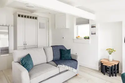 a living room with a couch and a table at Loe Cottage in Helston