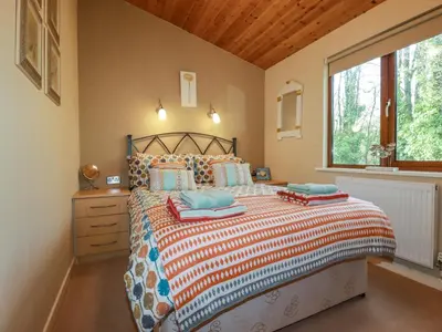 a bedroom with a large bed and a window at 4 The Glade in Wadebridge