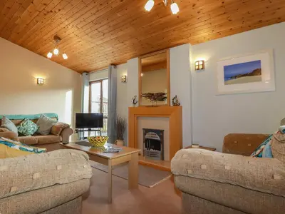 a living room with two couches and a fireplace at 4 The Glade in Wadebridge