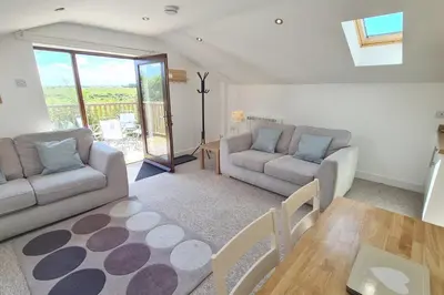 a living room with a couch and a table at Stable Barn Apartment in Saint Breward