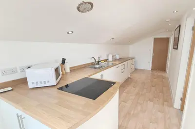 a kitchen with a sink and a microwave on a counter at Stable Barn Apartment in Saint Breward