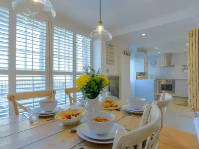 a dining room with a table with bowls of food at Apartment Tintagel Sea view by Interhome in Treknow