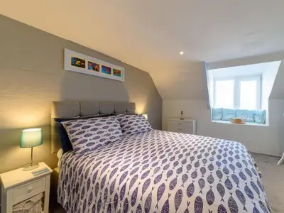 a bedroom with a bed and a window at Holiday Home Stargazey Cottage by Interhome in Mevagissey