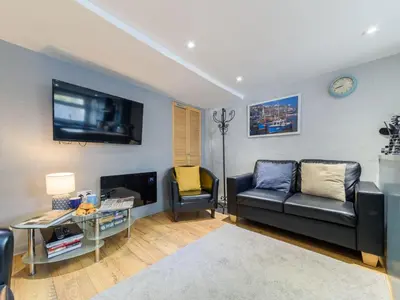 a living room with a couch and a tv at Holiday Home Stargazey Cottage by Interhome in Mevagissey