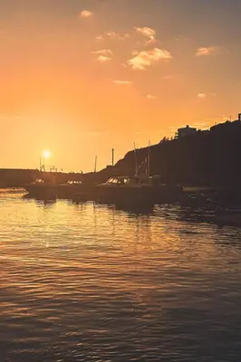 a sunset over a harbor with boats in the water at Holiday Home Stargazey Cottage by Interhome in Mevagissey