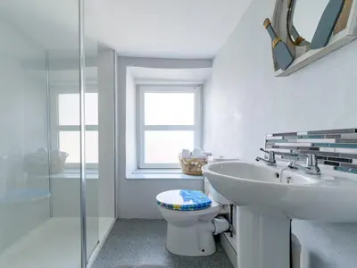 a white bathroom with a sink and a toilet at Holiday Home Stargazey Cottage by Interhome in Mevagissey