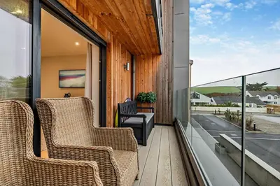 a porch with two chairs and a television on a balcony at 2 Bed in Harlyn Bay oc-s28921 in St Merryn
