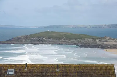 an island in the ocean with waves at 6 The Point - Walk to Newquay's Beaches - Free WiFi and Parking in Newquay