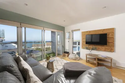 a living room with a couch and a flat screen tv at 6 The Point - Walk to Newquay's Beaches - Free WiFi and Parking in Newquay