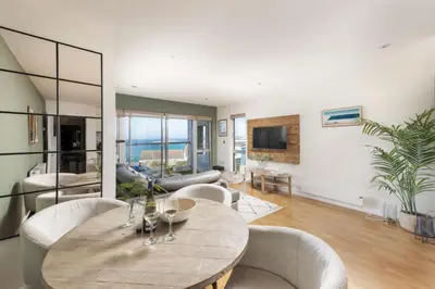 a living room with a table and chairs at 6 The Point - Walk to Newquay's Beaches - Free WiFi and Parking in Newquay