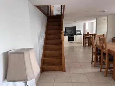 a kitchen and dining room with a staircase and a dining table at Cottages at the Lugger in Portloe