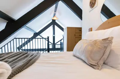 a bedroom with a white bed with a large window at Treworgie Barton - Trespaddick in Bude