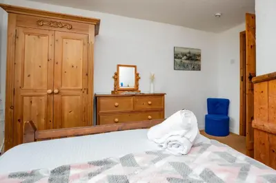a bedroom with a bed and a dresser and a mirror at Treworgie Barton - Trespaddick in Bude