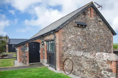 an old brick building with a black door at Treworgie Barton - Trespaddick in Bude