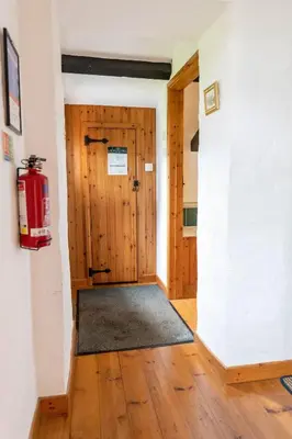 a hallway with a wooden door in a room at Treworgie Barton - Trespaddick in Bude