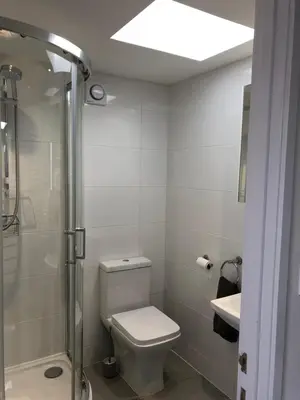 a bathroom with a toilet and a shower and a sink at Sunnyside Retreat in St Ives