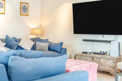 a living room with a blue couch and a flat screen tv at 4 Bed in St. Merryn oc-t29153 in St Merryn