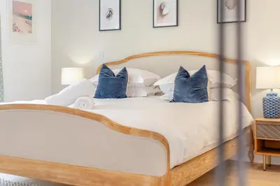 a bedroom with a bed with blue and white pillows at 4 Bed in St. Merryn oc-t29153 in St Merryn