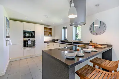 a kitchen with white cabinets and a large island at 3 Bed in Trevone oc-c29020 in Padstow