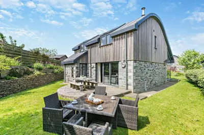 a house with a table and chairs in a yard at 3 Bed in Trevone oc-c29020 in Padstow