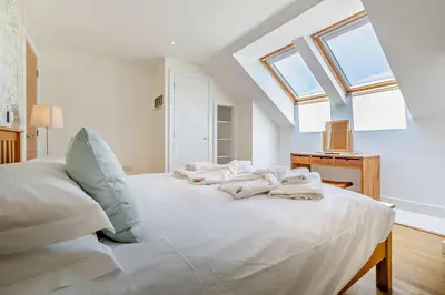 a bedroom with a large white bed with skylights at 3 Bed in Trevone oc-c29020 in Padstow