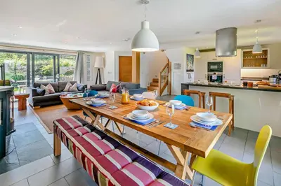 a kitchen and a living room with a wooden table at 3 Bed in Trevone oc-c29020 in Padstow