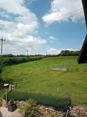 a large grassy field with a gate in the middle at Trelowen Cottage in Callington