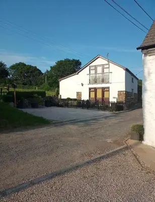 a white house sitting on the side of a road at Trelowen Cottage in Callington