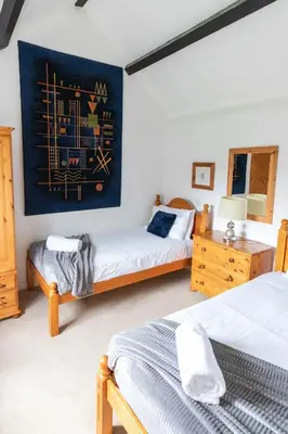 a bedroom with two beds and a painting on the wall at Treworgie Barton - Braddon in Bude
