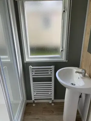 a bathroom with a sink and a window at Cosy Caravan New for 2024! in Newquay