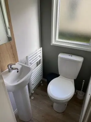 a bathroom with a white toilet and a sink at Cosy Caravan New for 2024! in Newquay