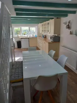 a kitchen with a white table and chairs in a room at Rural Cornish farmhouse in Liskeard