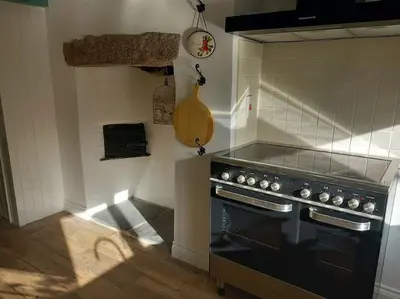 a kitchen with a stove top oven in a room at Rural Cornish farmhouse in Liskeard