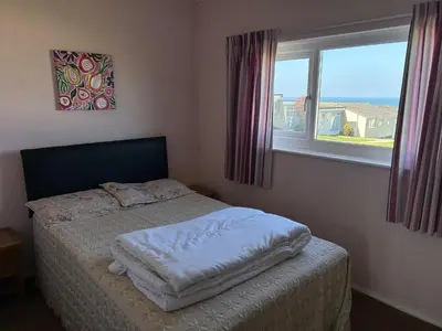 a small bed in a bedroom with a window at Bungalow 19 in Poundstock