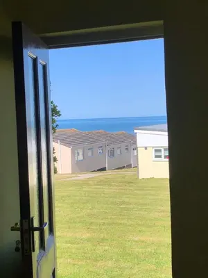 an open door with a view of a yard at Bungalow 19 in Poundstock