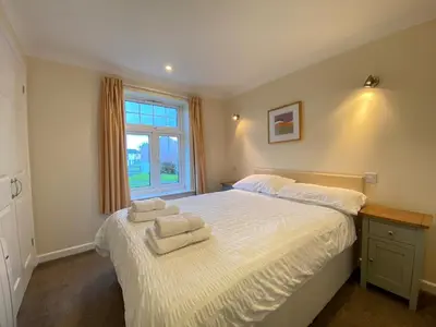 a bedroom with a white bed with towels on it at 4 Bedroom House at Atlantic Reach-Newquay-Cornwall in Newquay
