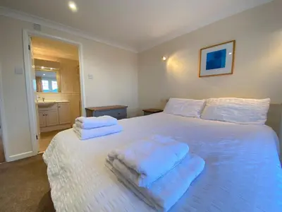 a bedroom with a white bed with towels on it at 4 Bedroom House at Atlantic Reach-Newquay-Cornwall in Newquay
