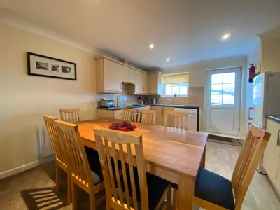 a kitchen with a large wooden table and chairs at 4 Bedroom House at Atlantic Reach-Newquay-Cornwall in Newquay