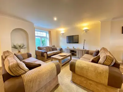 a living room with two couches and a tv at 4 Bedroom House at Atlantic Reach-Newquay-Cornwall in Newquay