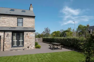 a stone building with a picnic table in the yard at Chy An Gweal Farm Cottage in Carbis Bay