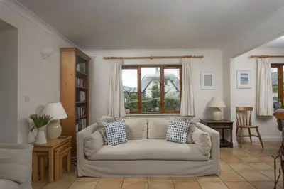 a living room with a couch and a window at Godolphin in Wadebridge