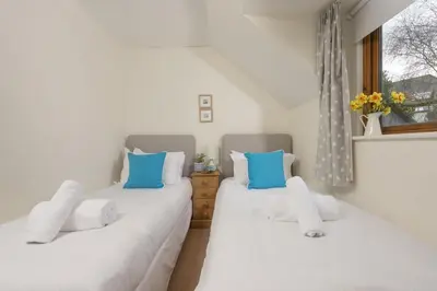 two twin beds in a room with a window at Godolphin in Wadebridge