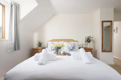 a bedroom with a large white bed with white pillows at Godolphin in Wadebridge