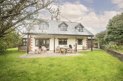 a house with a patio and grass yard at Godolphin in Wadebridge
