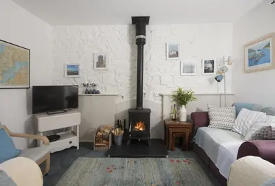 a living room with a couch and a fireplace at Roseland Cottage in Truro