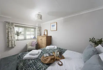 a bedroom with a bed with a cross on it at Roseland Cottage in Truro