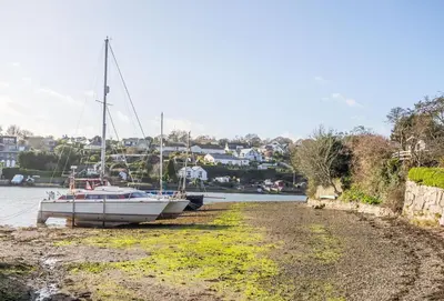 a boat sitting on the shore of a body of water at Roseland Cottage in Truro